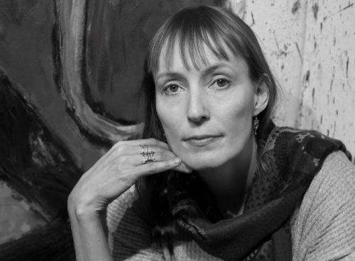 A person sitting posing for the camera Description automatically generated