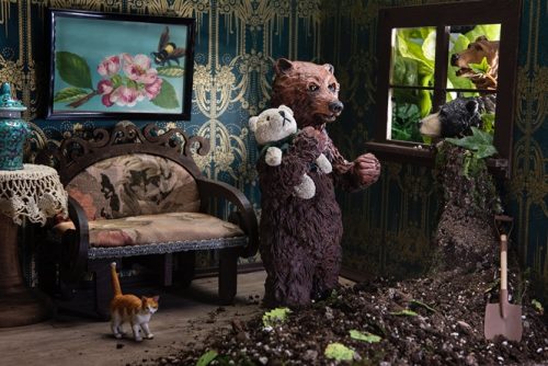 A teddy bear sitting on top of a building Description automatically generated