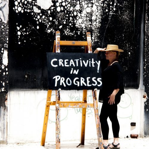 A person standing in front of a sign Description automatically generated