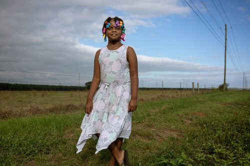 A person standing on top of a grass covered field Description automatically generated