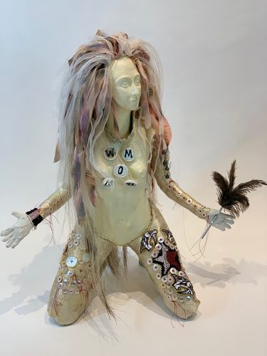 A picture containing doll, toy, white, holding Description automatically generated