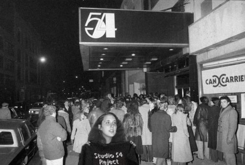 A group of people standing in front of a crowd Description automatically generated