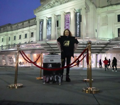A person standing in front of a building Description automatically generated