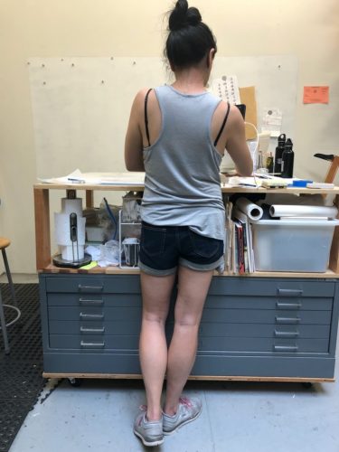 A person standing in a kitchen Description automatically generated