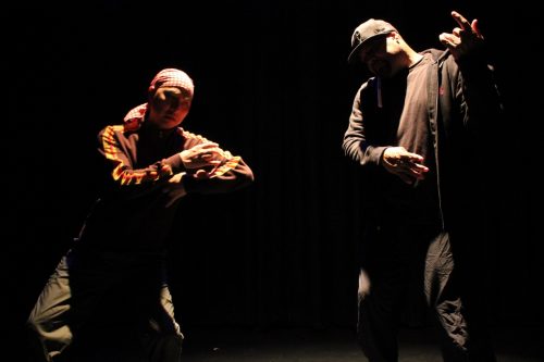 A group of people standing in the dark Description automatically generated