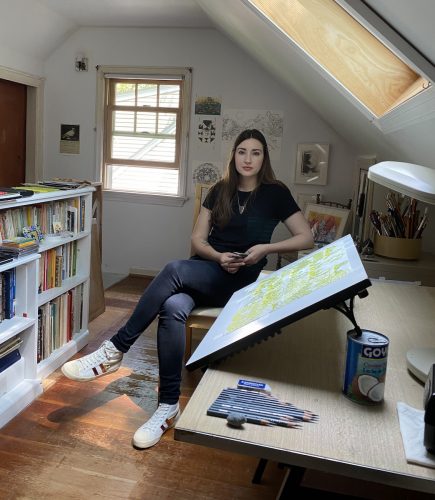 A person sitting on a couch holding a board Description automatically generated with low confidence