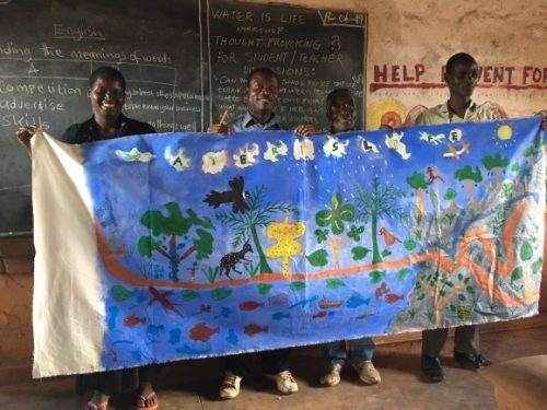 A group of people holding a banner Description automatically generated with medium confidence