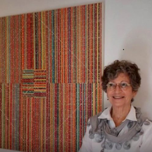 A person smiling in front of a curtain Description automatically generated with low confidence