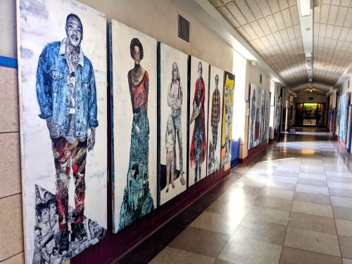 A hallway with art on the walls Description automatically generated with low confidence