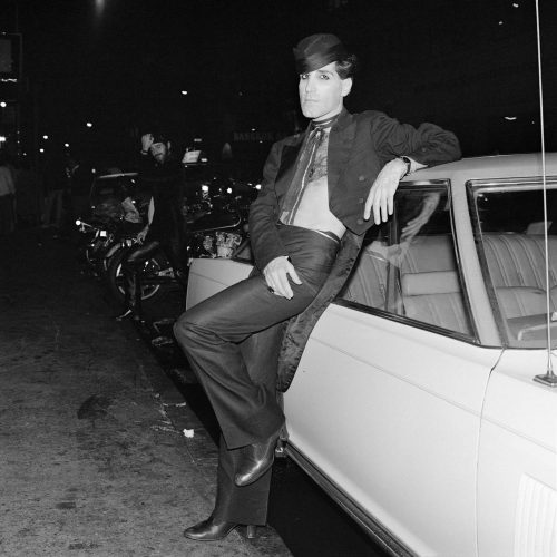 A person sitting on the hood of a car Description automatically generated with medium confidence