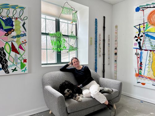 A person sitting on a couch with a dog Description automatically generated