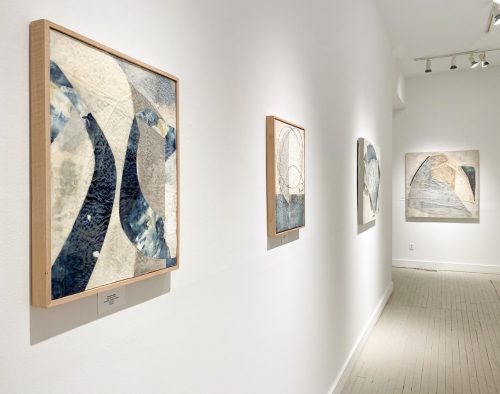 A long hallway with art on the wall Description automatically generated