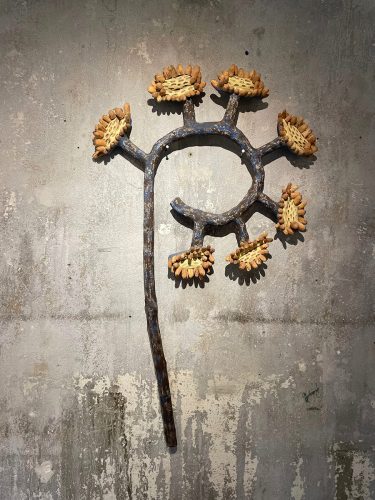 A metal object with flowers on a stick Description automatically generated