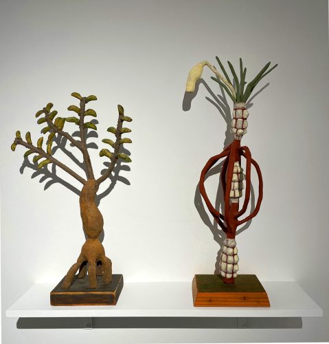 Two sculptures on a shelf Description automatically generated