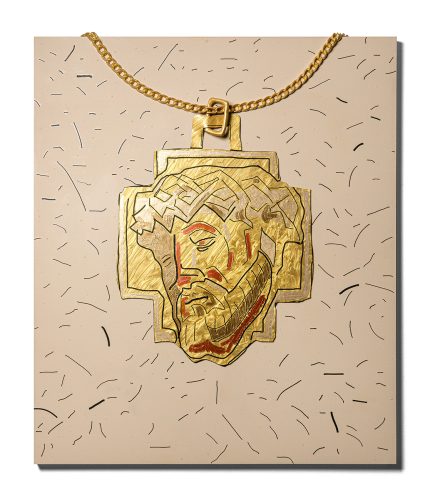 A gold necklace with a face of person on it Description automatically generated