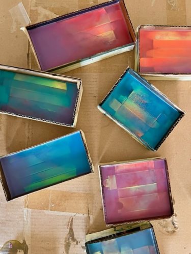 A group of boxes with different colored objects Description automatically generated