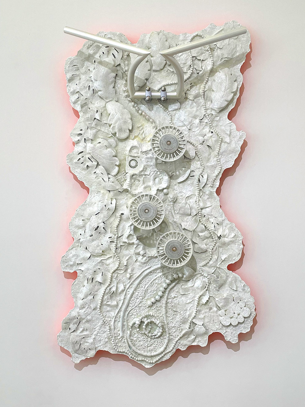 A white sculpture with gears and flowers

Description automatically generated