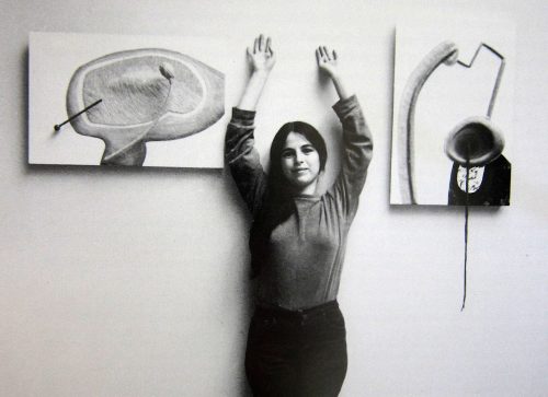 A person standing in front of a wall with her hands up Description automatically generated