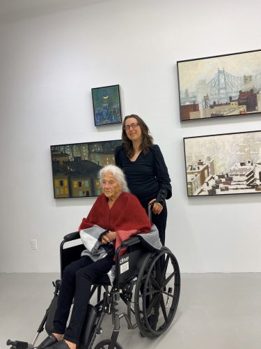 A person standing next to an older person in a wheelchair Description automatically generated