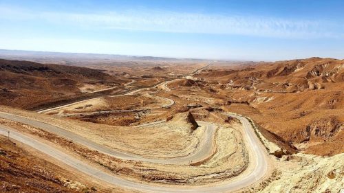 A winding road in the desert Description automatically generated