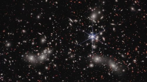 Stars in outer space with a bright star Description automatically generated