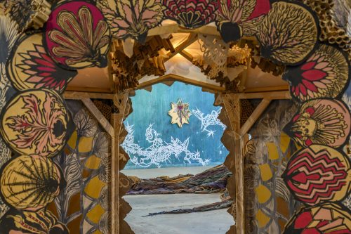 A colorful doorway with a blue wall and white and black artwork Description automatically generated with medium confidence