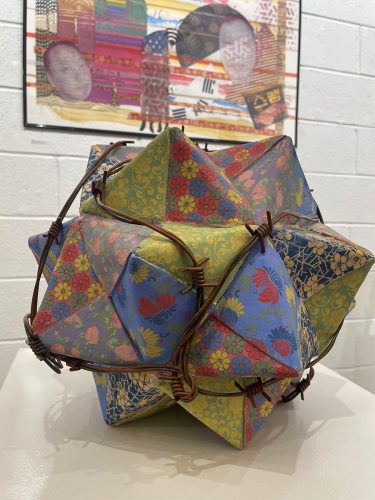 A colorful paper ball with barbed wire Description automatically generated with medium confidence