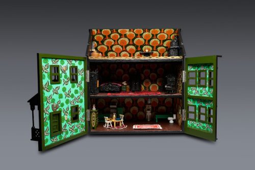 A dollhouse with a doll and a table Description automatically generated with medium confidence