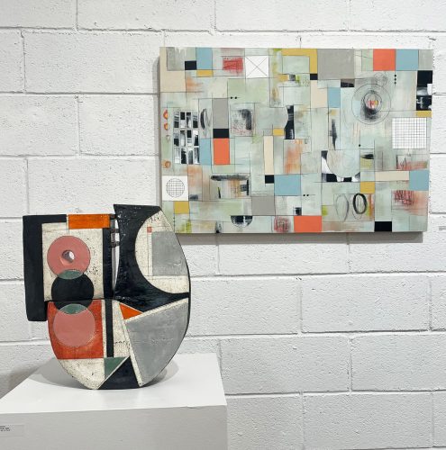 A piece of art on a white surface next to a painting Description automatically generated