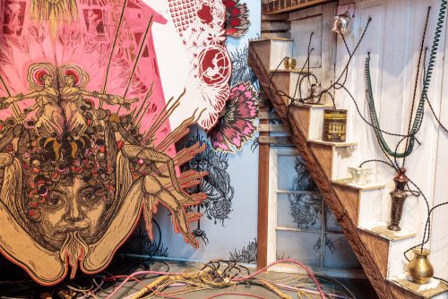 A room with a staircase and a drawing of a person Description automatically generated