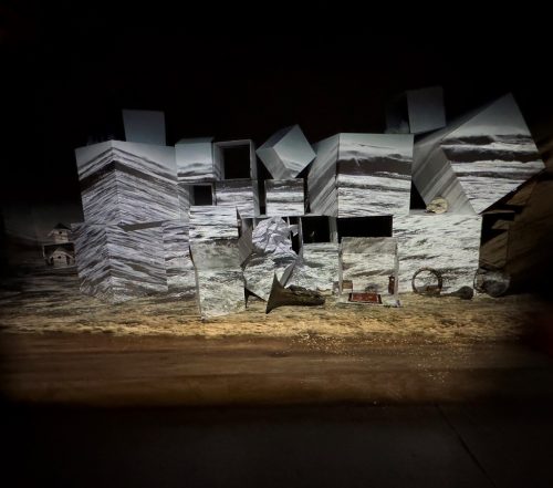 A group of buildings on a beach Description automatically generated