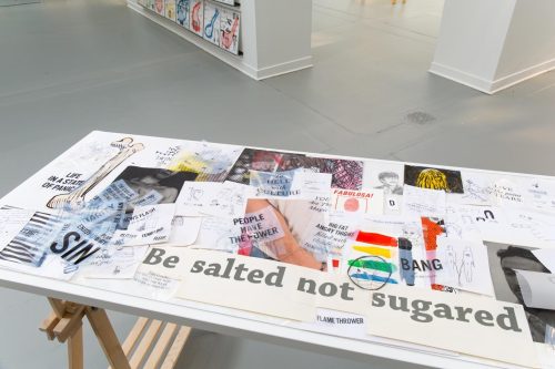 A table with many pieces of paper on it Description automatically generated