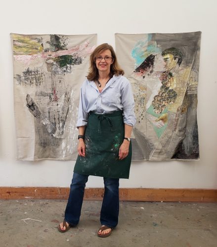 A person standing in front of a wall with paintings Description automatically generated