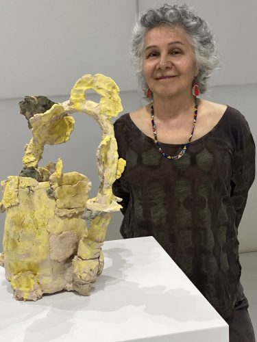 A person standing next to a sculpture Description automatically generated