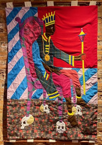 A colorful piece of art on a brick wall Description automatically generated