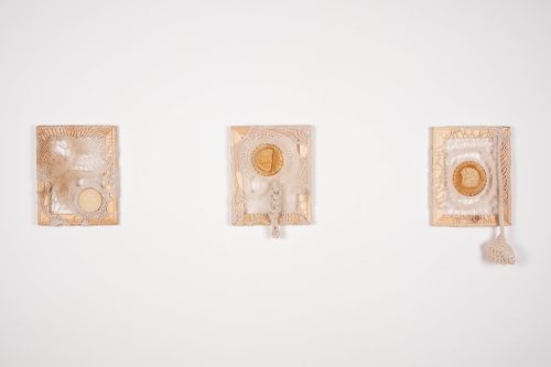 A group of art pieces on a wall Description automatically generated