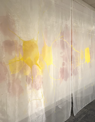 A white curtain with yellow paint on it Description automatically generated