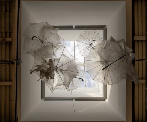 A group of umbrellas from a ceiling Description automatically generated