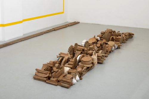 A group of wooden objects on a white floor Description automatically generated