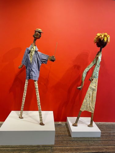 A couple of statues on white cubes Description automatically generated