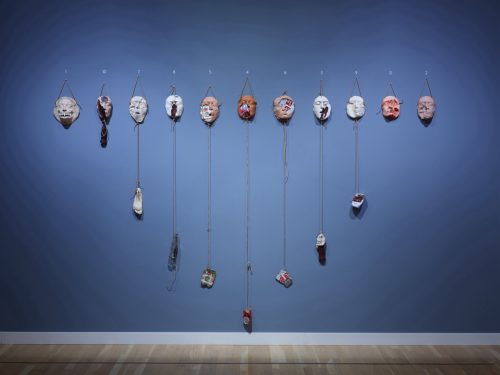 A group of masks on a wall AI-generated content may be incorrect.