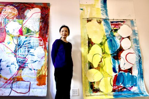 A person standing next to a painting AI-generated content may be incorrect.