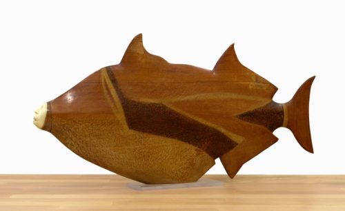 A wooden fish sculpture on a table AI-generated content may be incorrect.