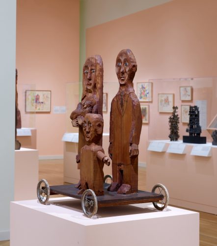 A wooden sculptures in a museum AI-generated content may be incorrect.