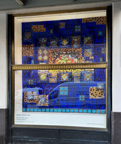 A window with a blue and gold art piece Description automatically generated